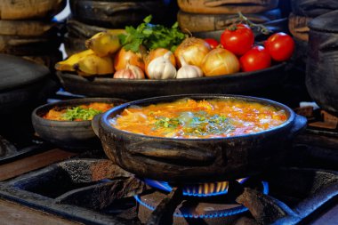 Lezzetli Moqueca capixaba ve kil kaplarda sebzeler