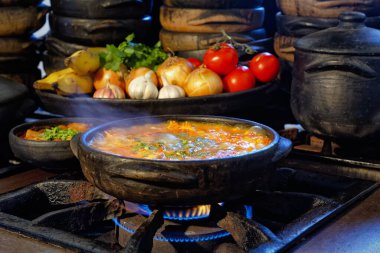 Lezzetli Moqueca capixaba ve kil kaplarda sebzeler