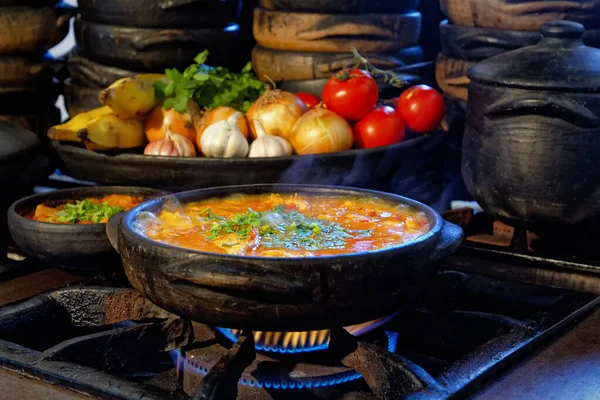 Lezzetli Moqueca capixaba ve kil kaplarda sebzeler