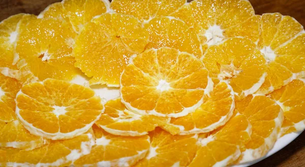 Oranges cut into slices served on white platter.