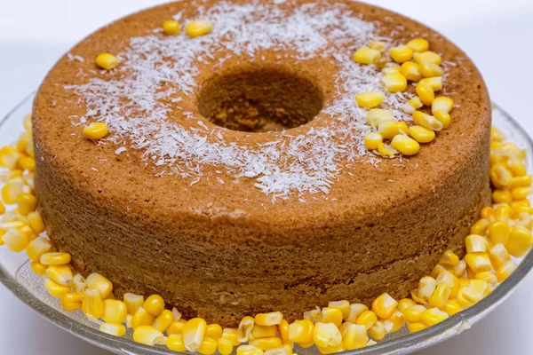 Delicious homemade corn cake served on a transparent plate and decorated with corn kernels.