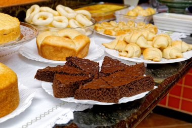 Lezzetli ekmekler, kekler, peynirli ekmek ve simit ile kahvaltı masası..