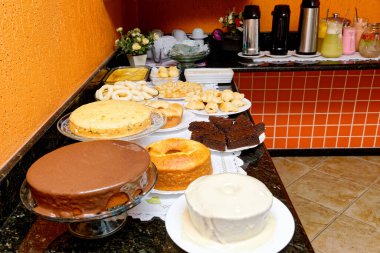 Çeşitli lezzetli ekmekler, kekler, peynirli ekmek ve simit içeren kahvaltı masası..