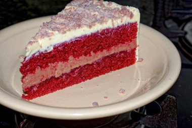 Tabağında dondurma olan bir dilim peynirli pasta.