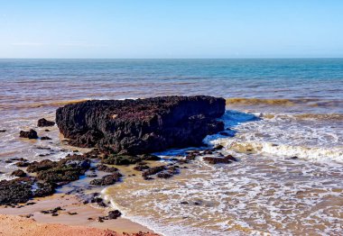 Sahilde deniz dalgalarıyla kayalar