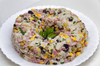 Beyaz tabakta servis edilen turba salatası, mısır, ekmek ve mayonez.