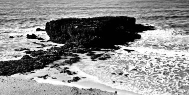 Sahilde deniz dalgalarıyla kayalar