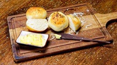 Tahtada tereyağlı kekikli patates ekmeği servis ediliyor..