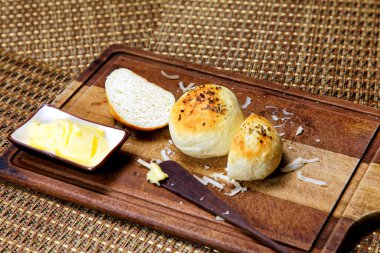 Tahtada tereyağlı kekikli patates ekmeği servis ediliyor..