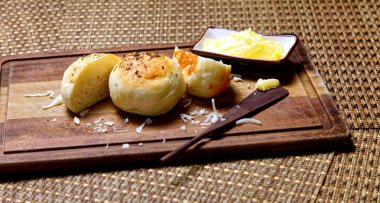 Tahtada tereyağlı kekikli patates ekmeği servis ediliyor..