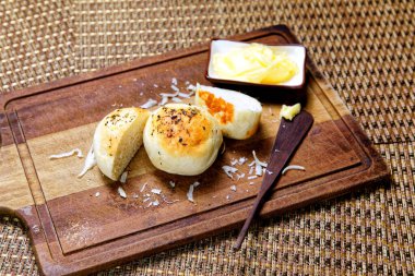 Tahtada tereyağlı kekikli patates ekmeği servis ediliyor..