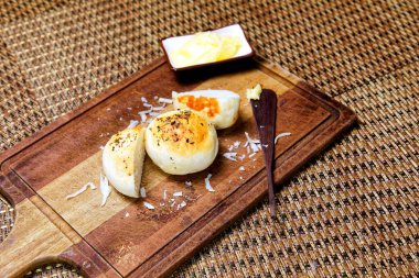 Tahtada tereyağlı kekikli patates ekmeği servis ediliyor..