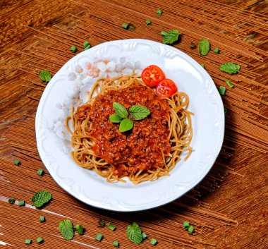 Bolonez soslu Fettuccine, fesleğen ve kiraz domatesleriyle süslenmiş, yanında kekik ekmeği..