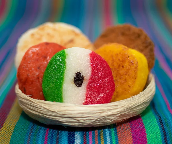 basket with a bunch of typical mexican coconut candies honey cocada traditional mexican flag carpet background isolated colors sarape mexican
