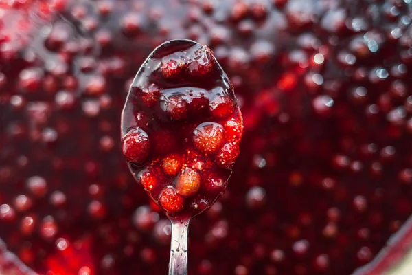 Strawberry jam in a metal spoon closeup — Stock Photo, Image