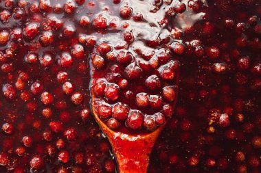 tahta bir kaşık çilek reçeli batırılır