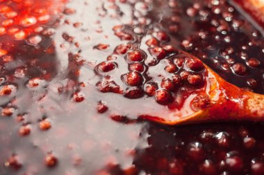 tahta bir kaşık çilek reçeli batırılır