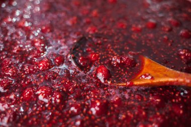 bir tahta kaşık ahududu reçeli batırılır