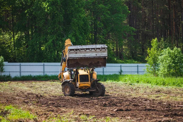 Yellow excavator with a large wide open bucket