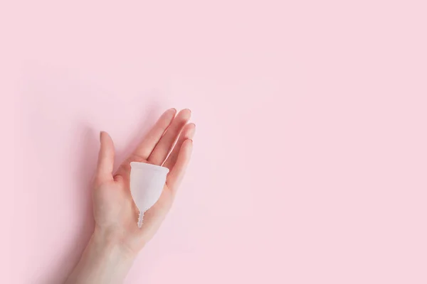 La mano femenina sostiene la copa menstrual de silicona. Higiene íntima reutilizable — Foto de Stock