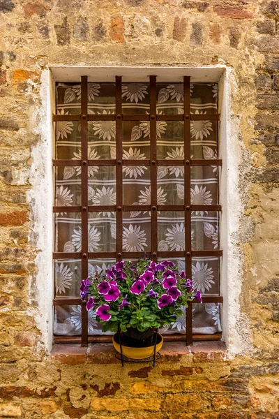 Zdobená okna ve středověkých ulicích San Gimignana v Toskánsku — Stock fotografie