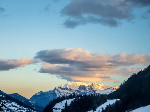 Ein früher Sonnenaufgang auf den schneebedeckten Bergen in der Schweiz — Stockfoto