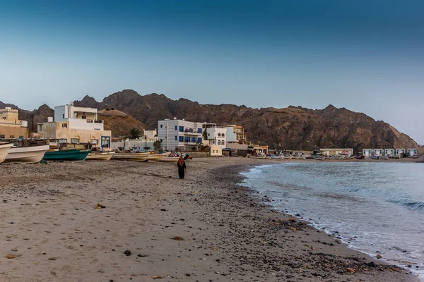 Místní žena procházející se na pobřeží Ománu na slunci — Stock fotografie