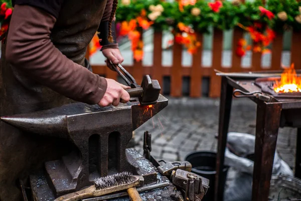 A blacksmith hammering a red hot horse nail at s Czech Christmas — Stock Photo, Image