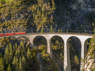 İsviçre Alpleri 1 'de nefes kesen bir köprüde tren tırmanıyor.