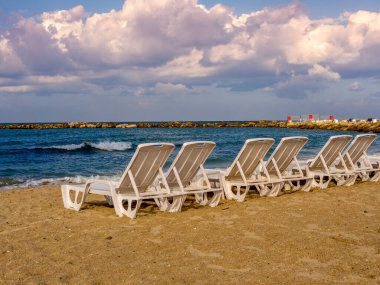 Sonbaharda boş bir sahilde sandalyeler