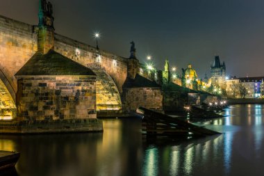 Soğuk kış gecelerinde Prag 'daki Charles Köprüsü ve Vltava Nehri manzarası