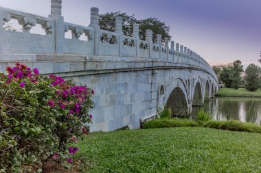 Çin mermer köprüsü tapınakları Singapur 'daki Çin bahçesindeki göle yansıyor.