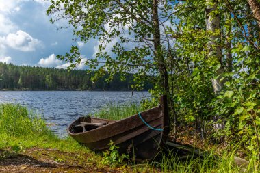 Finlandiya 'daki Saimaa gölünün kıyısında eski ahşap bir kayık.