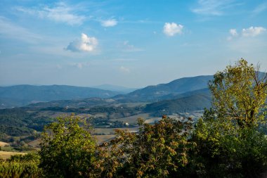 Toskana 'nın ortaçağ şehri Guardistallo' nun etrafındaki çatılar, kuleler ve tepeler.