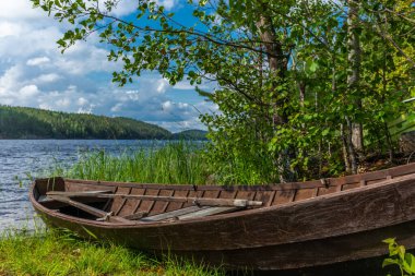 Finlandiya 'daki Saimaa gölünün kıyısında eski ahşap bir kayık.