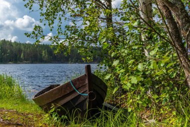 Finlandiya 'daki Saimaa gölünün kıyısında eski ahşap bir kayık.