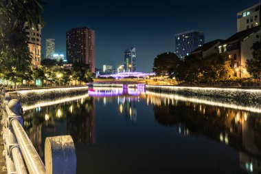Modern brightly illuminated bridge on the Singapore river at night