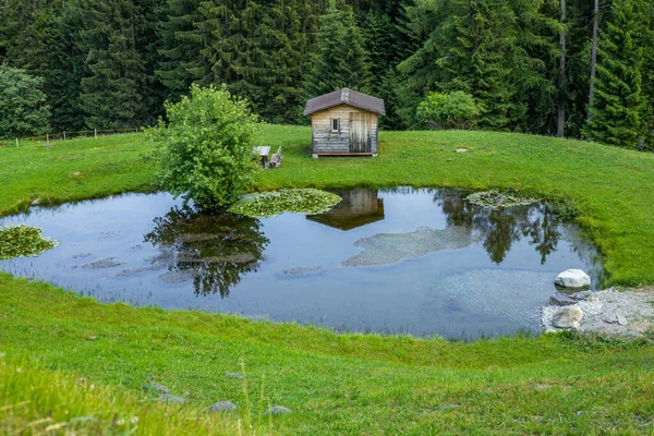 İsviçre 'nin Graubunden kantonundaki Tschappina' da küçük bir göl kenarında ahşap bir kulübe.
