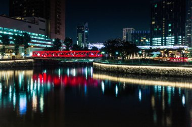 Modern brightly illuminated bridge on the Singapore river at night