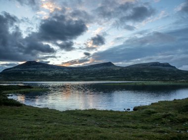 Norveç 'teki Rondane Ulusal Parkı' nda gün batımında Norveç gölüne yansıyan bulutlar