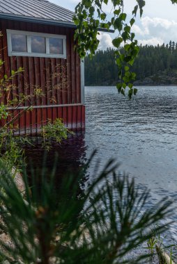 Finlandiya 'daki Saimaa gölünün kıyısındaki tipik kırmızı kayıkhane.