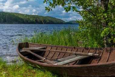 Finlandiya 'daki Saimaa gölünün kıyısında eski ahşap bir kayık.