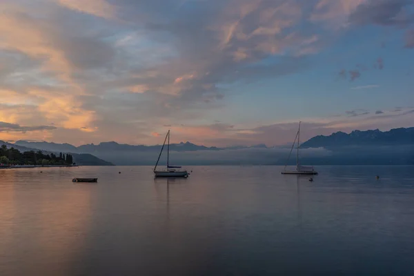 瑞士阿尔卑斯山背景下的勒曼湖畔的洛桑码头升起了多彩的日出 — 图库照片