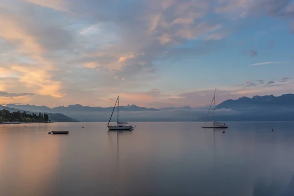 瑞士阿尔卑斯山背景下的勒曼湖畔的洛桑码头升起了多彩的日出 — 图库照片