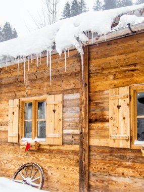 The wall and windows of a wooden chalet in the Swiss Alps in winter