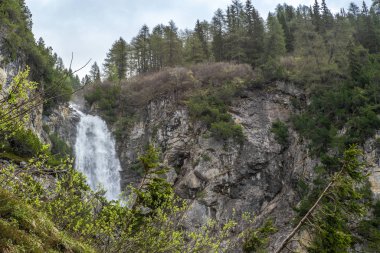 Güneşli bir bahar gününde İsviçre Alplerinde Lenzerheide yakınlarındaki şelale manzarası 