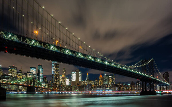 View of the Manhattan Bridge and Manhattan from the riverside of the East River at night