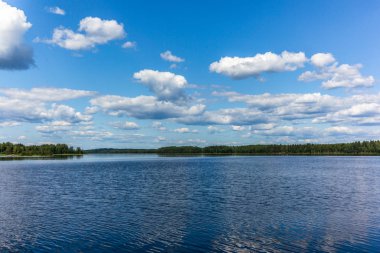 Finlandiya 'daki Linnansaari Ulusal Parkı' ndaki Saimaa gölünün sakin sularını yansıtan beyaz bulutlar 