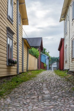 Finlandiya 'nın Porvoo şehrinde yaz akşamları kaldırımlı sokaklar ve renkli boyanmış eski ahşap evler 