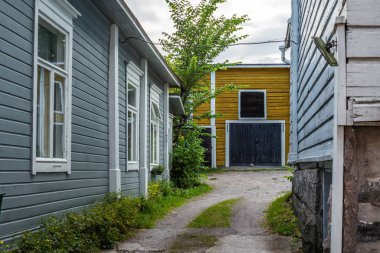 Finlandiya 'nın Porvoo şehrinde yaz akşamları kaldırımlı sokaklar ve renkli boyanmış eski ahşap evler 